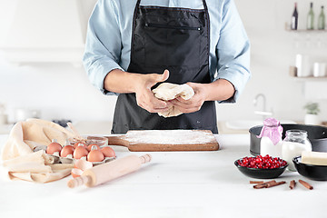 Image showing A cook with eggs on a rustic kitchen against the background of men\'s hands