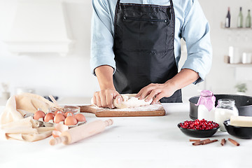 Image showing A cook with eggs on a rustic kitchen against the background of men\'s hands