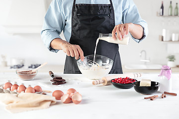 Image showing A cook with eggs on a rustic kitchen against the background of men\'s hands