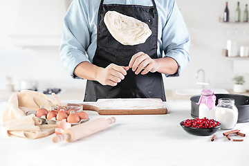 Image showing A cook with eggs on a rustic kitchen against the background of men\'s hands