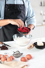 Image showing A cook with eggs on a rustic kitchen against the background of men\'s hands