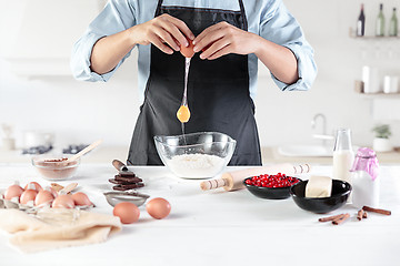 Image showing A cook with eggs on a rustic kitchen against the background of men\'s hands