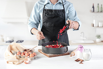 Image showing A cook with eggs on a rustic kitchen against the background of men\'s hands