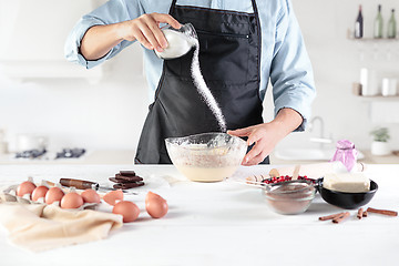 Image showing A cook with eggs on a rustic kitchen against the background of men\'s hands