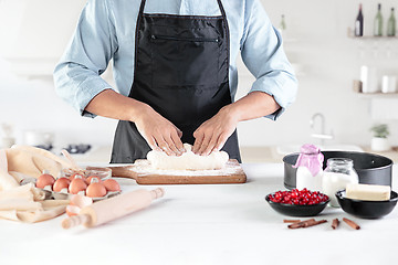 Image showing A cook with eggs on a rustic kitchen against the background of men\'s hands