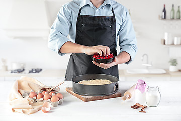 Image showing A cook with eggs on a rustic kitchen against the background of men\'s hands