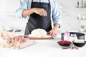 Image showing A cook with eggs on a rustic kitchen against the background of men\'s hands