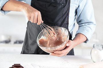 Image showing A cook with eggs on a rustic kitchen against the background of men\'s hands