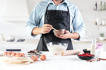 Image showing A cook with eggs on a rustic kitchen against the background of men\'s hands