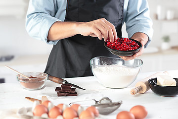 Image showing A cook with eggs on a rustic kitchen against the background of men\'s hands