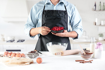 Image showing A cook with eggs on a rustic kitchen against the background of men\'s hands