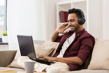 Image showing man in headphones with laptop listening to music