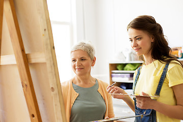 Image showing women with brushes painting at art school