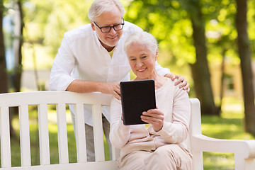 Image showing happy senior couple with tablet pc at summer park