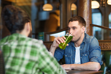 Image showing male friends drinking green beer at bar or pub