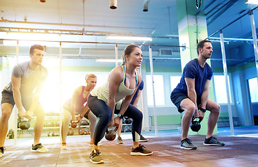 Image showing group of people with kettlebells exercising in gym