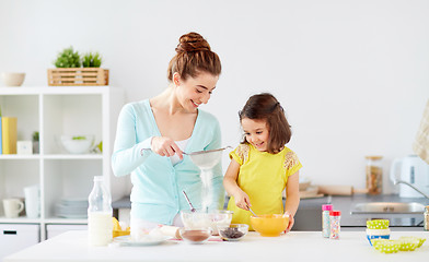 Image showing happy mother and daughter baking at home