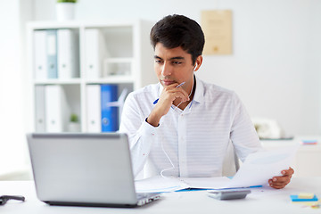 Image showing businessman in earphones working at office