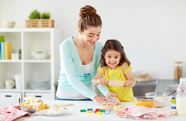 Image showing happy mother and daughter making cookies at home