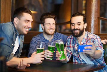 Image showing friends taking selfie with green beer at pub