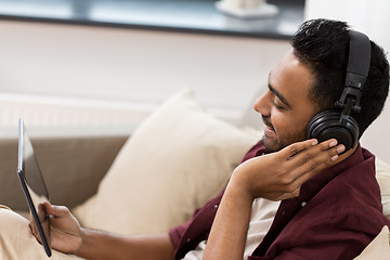 Image showing man in phones with tablet pc listening to music