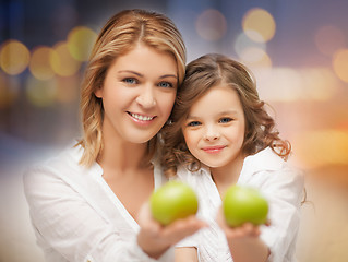 Image showing happy mother and daughter with green apples