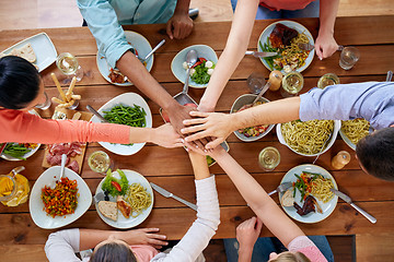 Image showing people holding hands together over table with food