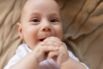 Image showing close up of sweet little baby boy lying on blanket