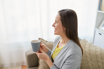 Image showing happy woman drinking tea or coffee at home