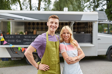 Image showing happy couple of young sellers at food truck
