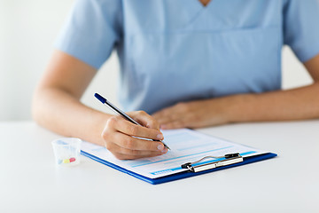 Image showing doctor with medicines and clipboard at hospital