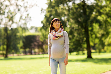 Image showing happy pregnant asian woman walking at park