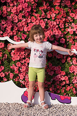 Image showing little cute girl in a flower garden