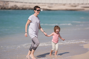 Image showing mother and daughter running on the beach