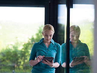 Image showing young women using tablet computer by the window