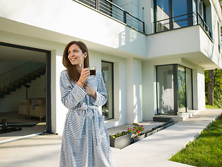 Image showing woman in a bathrobe enjoying morning coffee