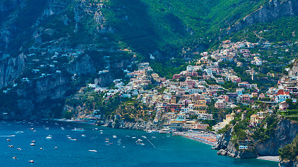 Image showing One of the best resorts of Italy with old colorful villas on the steep slope, nice beach, numerous yachts and boats in harbor and medieval towers along the coast, Positano.