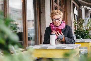 Image showing Adult woman with coffee and smartphone