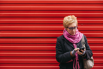 Image showing Adult woman with smartphone on street