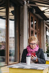 Image showing Woman with drink and smartphone