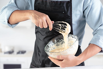 Image showing A cook with eggs on a rustic kitchen against the background of men\'s hands