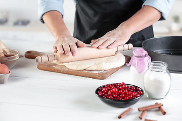 Image showing A cook with eggs on a rustic kitchen against the background of men\'s hands