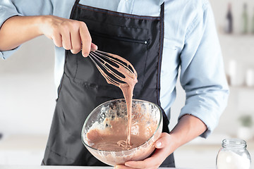 Image showing A cook with eggs on a rustic kitchen against the background of men\'s hands