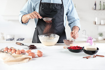 Image showing A cook with eggs on a rustic kitchen against the background of men\'s hands