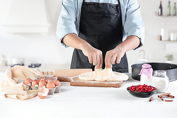 Image showing A cook with eggs on a rustic kitchen against the background of men\'s hands