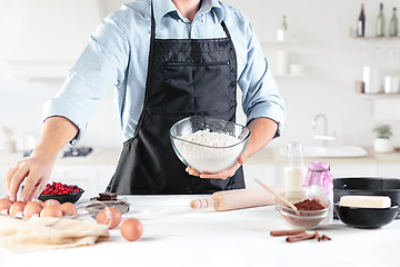 Image showing A cook with eggs on a rustic kitchen against the background of men\'s hands