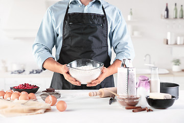 Image showing A cook with eggs on a rustic kitchen against the background of men\'s hands