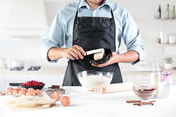 Image showing A cook with eggs on a rustic kitchen against the background of men\'s hands