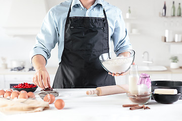 Image showing A cook with eggs on a rustic kitchen against the background of men\'s hands