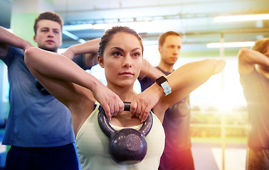 Image showing group of people with kettlebells exercising in gym